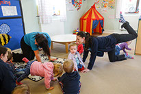 photo showing staff and children in Bumble Bees enjoying baby yoga at Longscroft