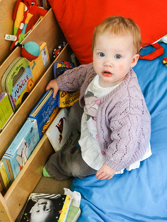 photo showing a baby playing with books at Longscroft