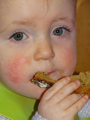 photo of a child from Bumble Bees room at Longscroft eating a snack of bread and butter