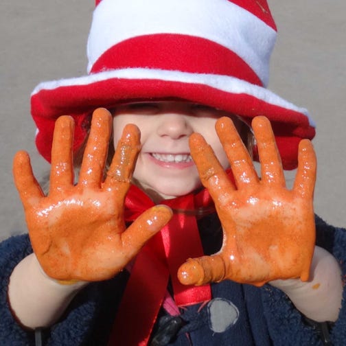 Photo of a girl with glitter hands playing at Longscroft Nursery
