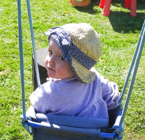 Photograph of a baby on swing in Bumble Bees garden at Longscroft Nursery