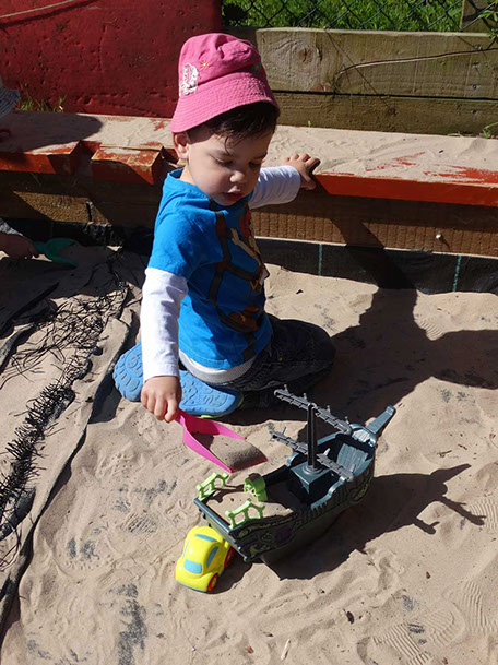 photo showing a boy playing in the sandpit at Longscroft
