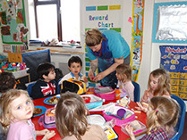 photo showing children sitting at a table eating lunch at Longscroft