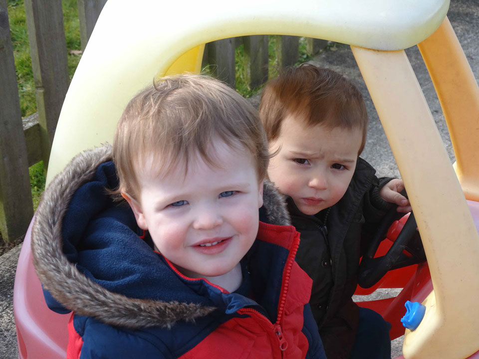 photo showing two baby boys playing in the play car at Longscroft