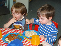 photo showing boys feeding themsleves in Dragonflies, Longscroft